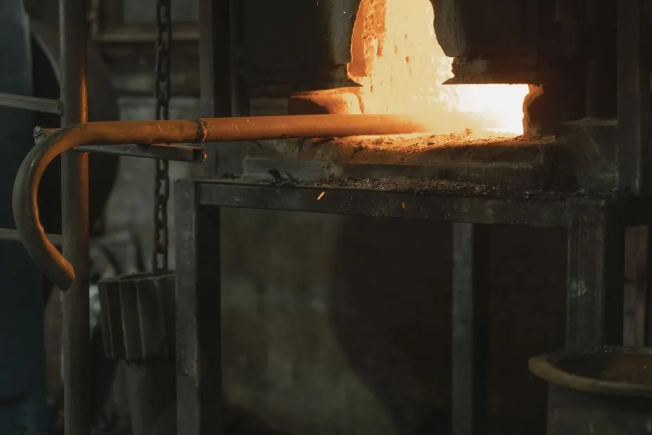 Close-up of metal being heated in a blacksmith forge, showcasing industrial craftsmanship.